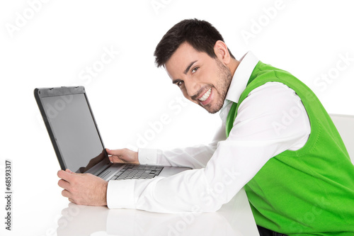 Beruf Informatiker: Mann isoliert in Grün mit Laptop photo