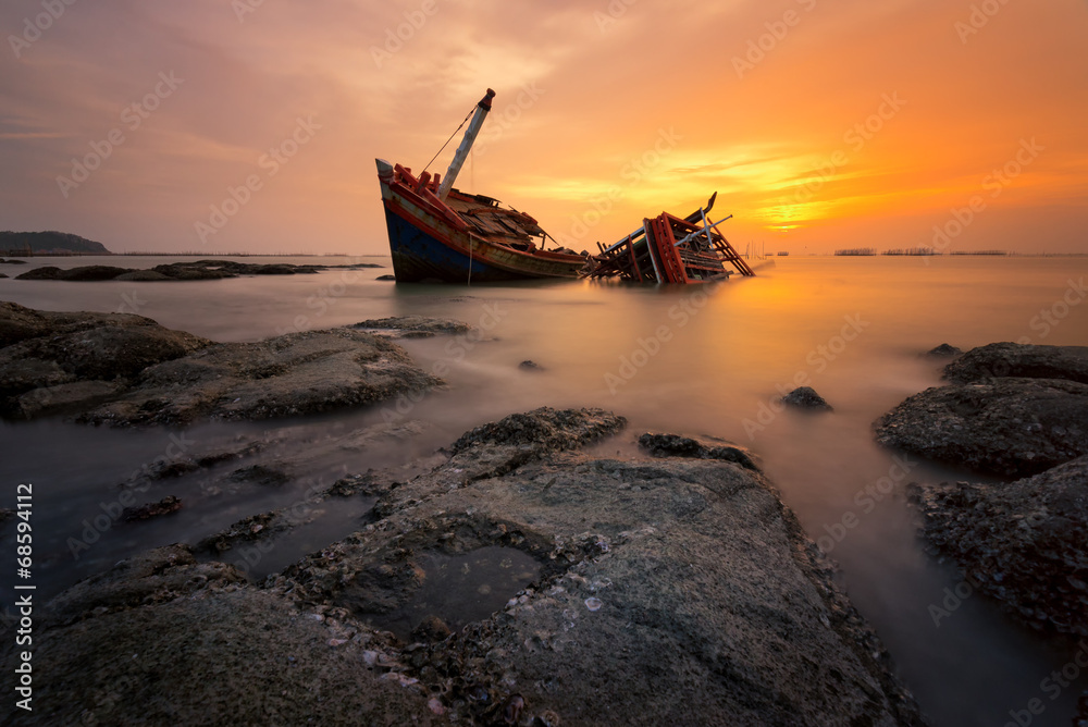 Fishing boat beached with sunset view Fishing boat beached with sunset view