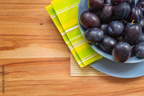 Ripe Plums on Wood Background