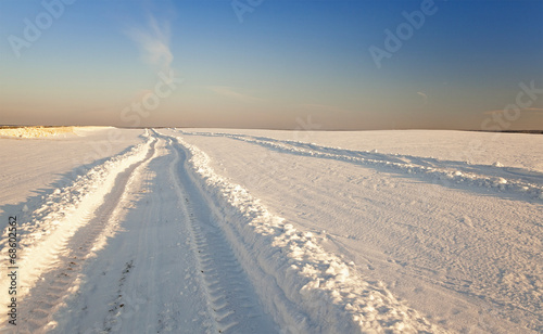  the rural road in an agricultural field in a winter season