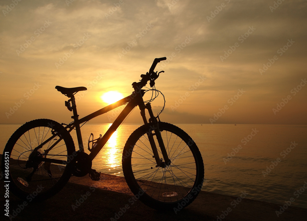 Silhouette bicycle beside sunset sea Silhouette bicycle beside sunset sea