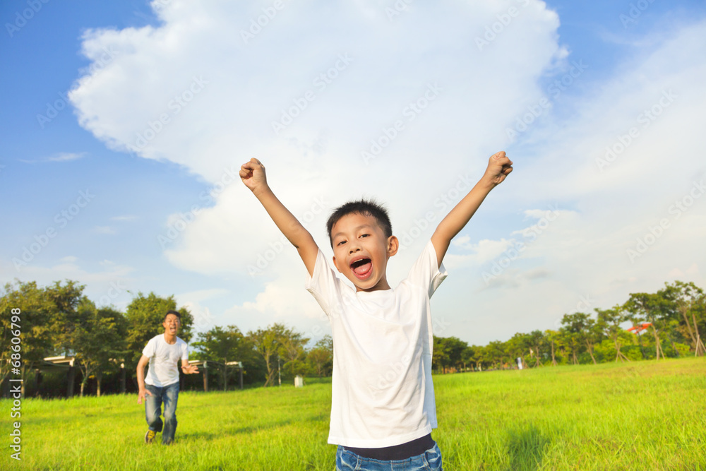 happy father and son playing in meadow happy father and son playing in meadow