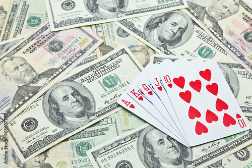 Playing cards on pile of US dollar banknotes