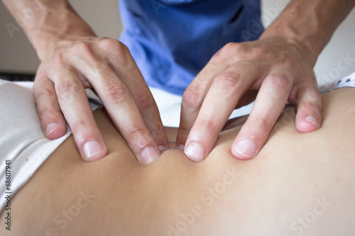 osteopath hands on patient back photo