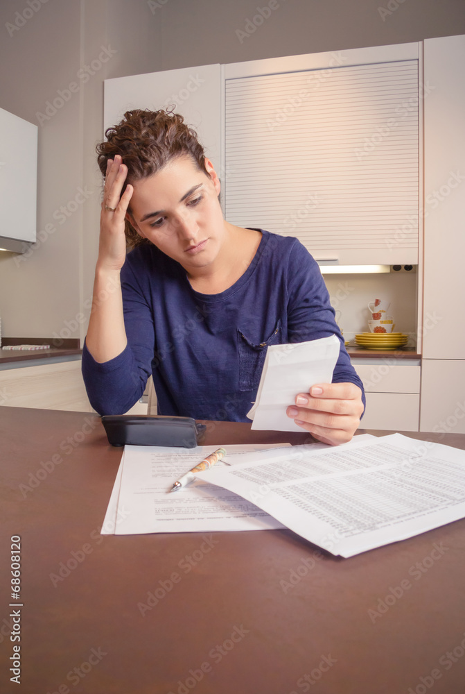 Unemployed and divorced woman with debts reviewing her monthly Unemployed and divorced woman with debts reviewing her monthly