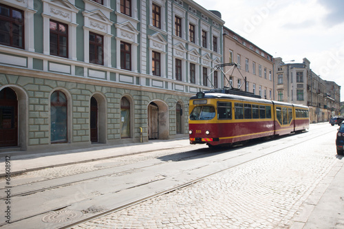 Stary tramwaj jedzie brukowaną ulicą