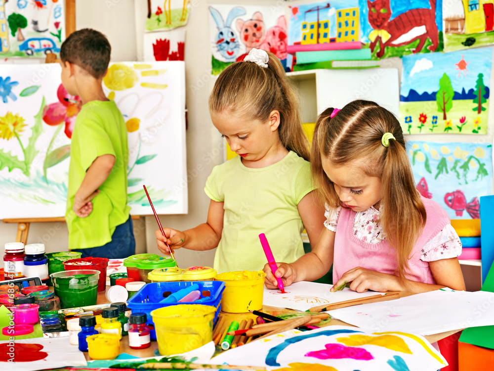 Fototapeta premium Child painting at easel.