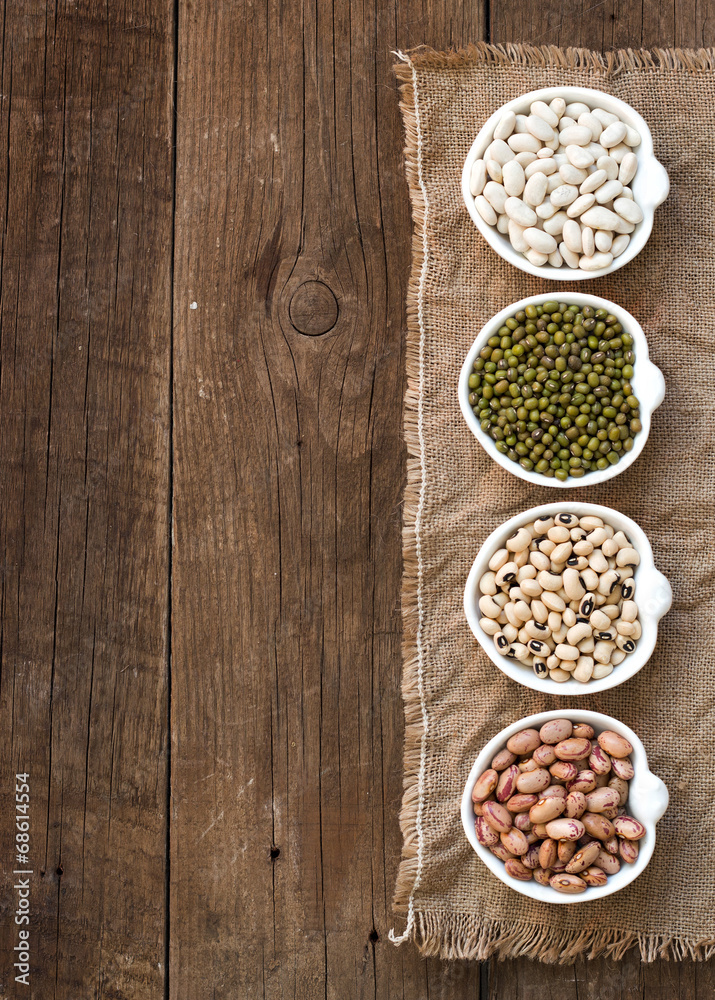Assortment of legumes in bowls on wooden table Assortment of legumes in bowls on wooden table