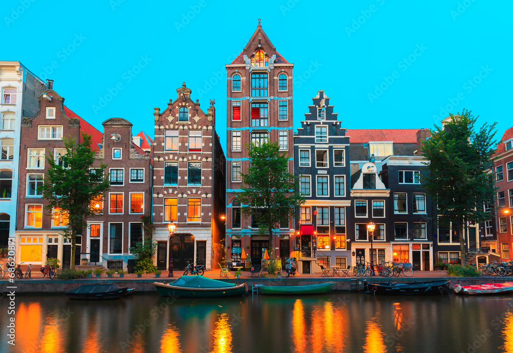 Naklejka premium Nocny widok na kanały Amsterdamu i typowe domy, Holandia,