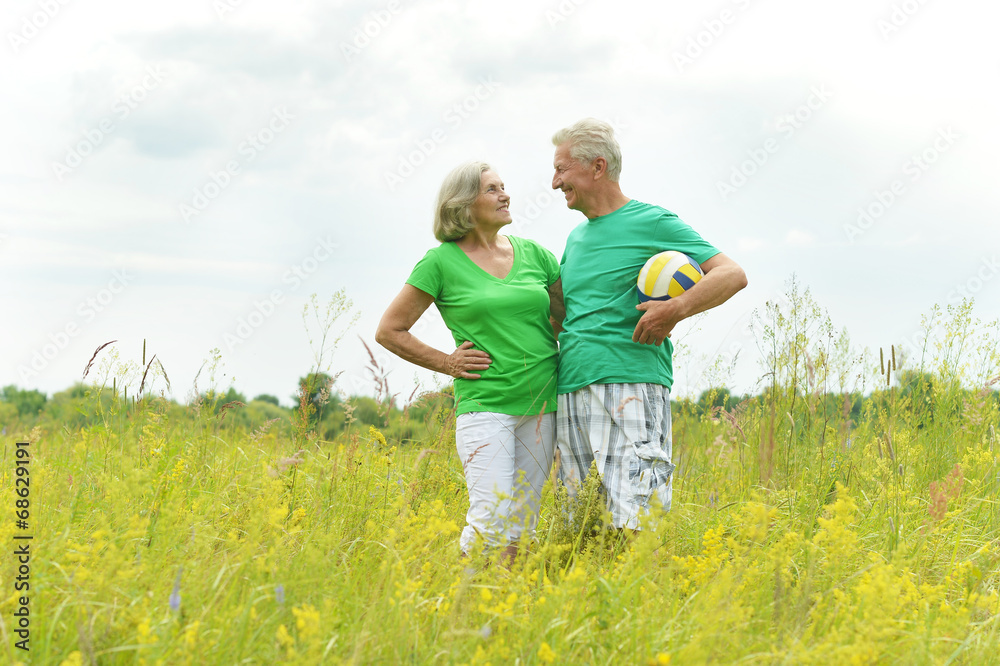 Senior couple in field with ball