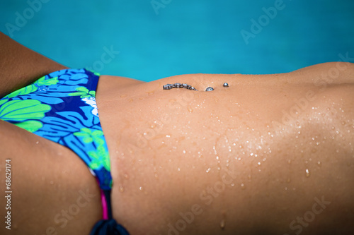 Girl relaxing in a swimming pool, body close up
