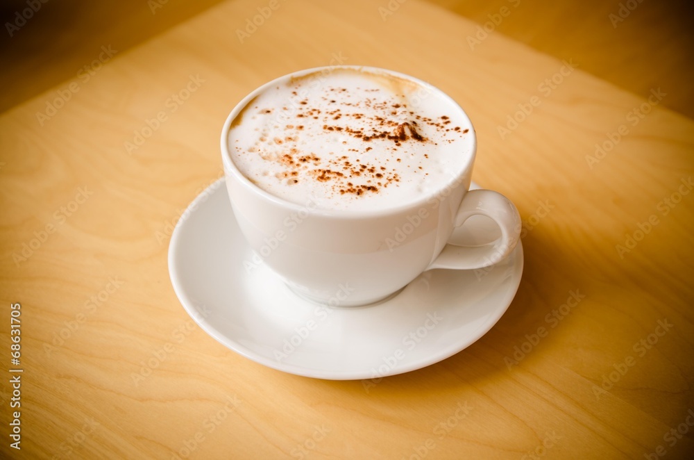 cup of cappucchino over wooden table cup of cappucchino over wooden table