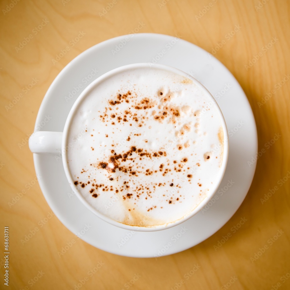 cup of cappucchino over wooden table cup of cappucchino over wooden table
