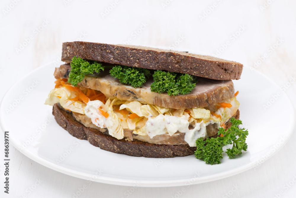 sandwich with coleslaw and baked meat on the plate