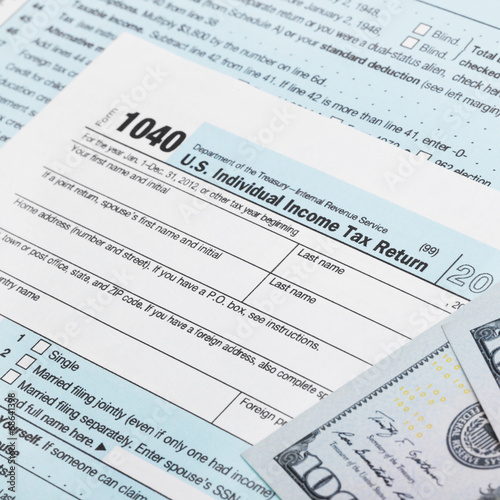 USA Tax Form 1040 with 100 US dollar bills