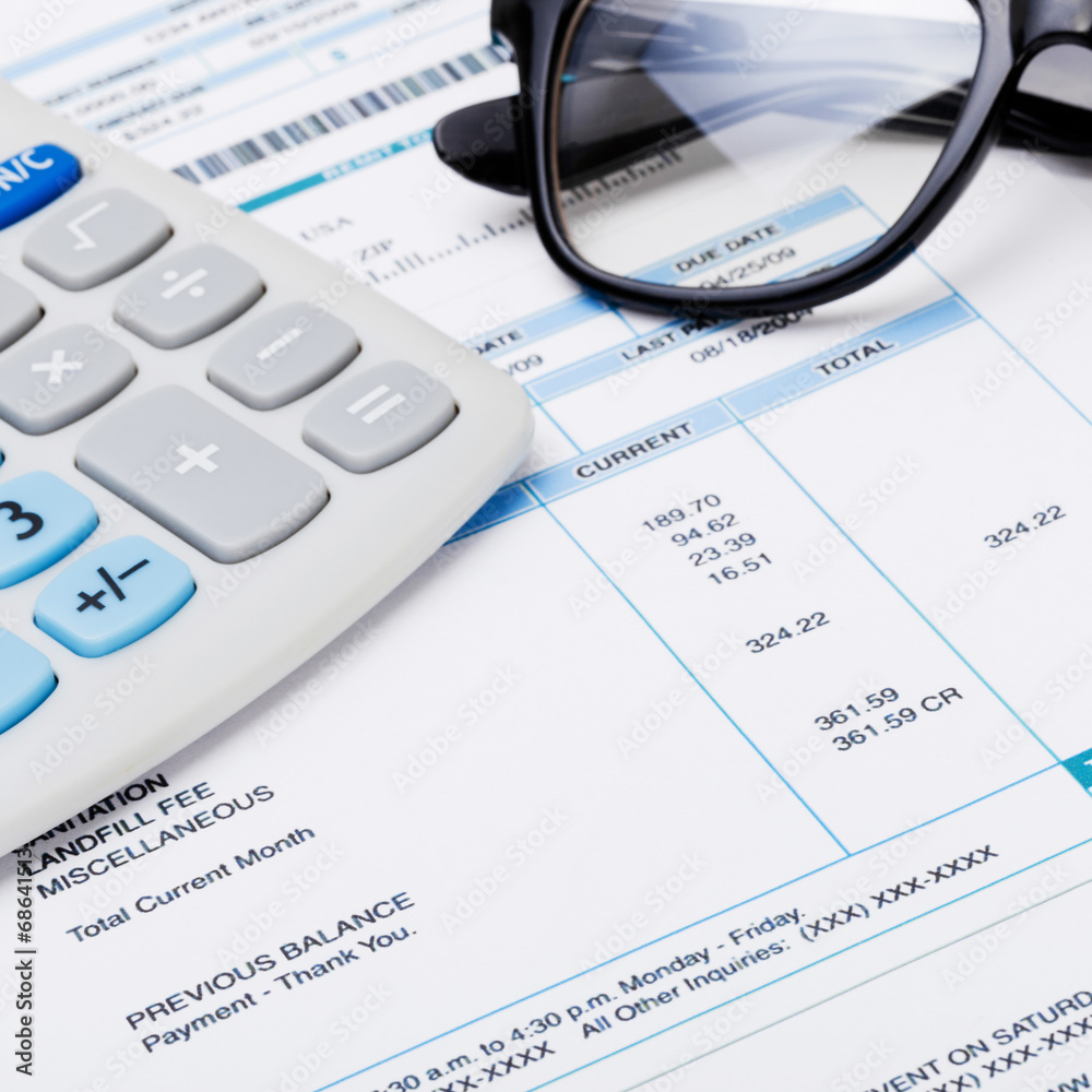 Studio shot of calculator and glasses over some receipt Studio shot of calculator and glasses over some receipt