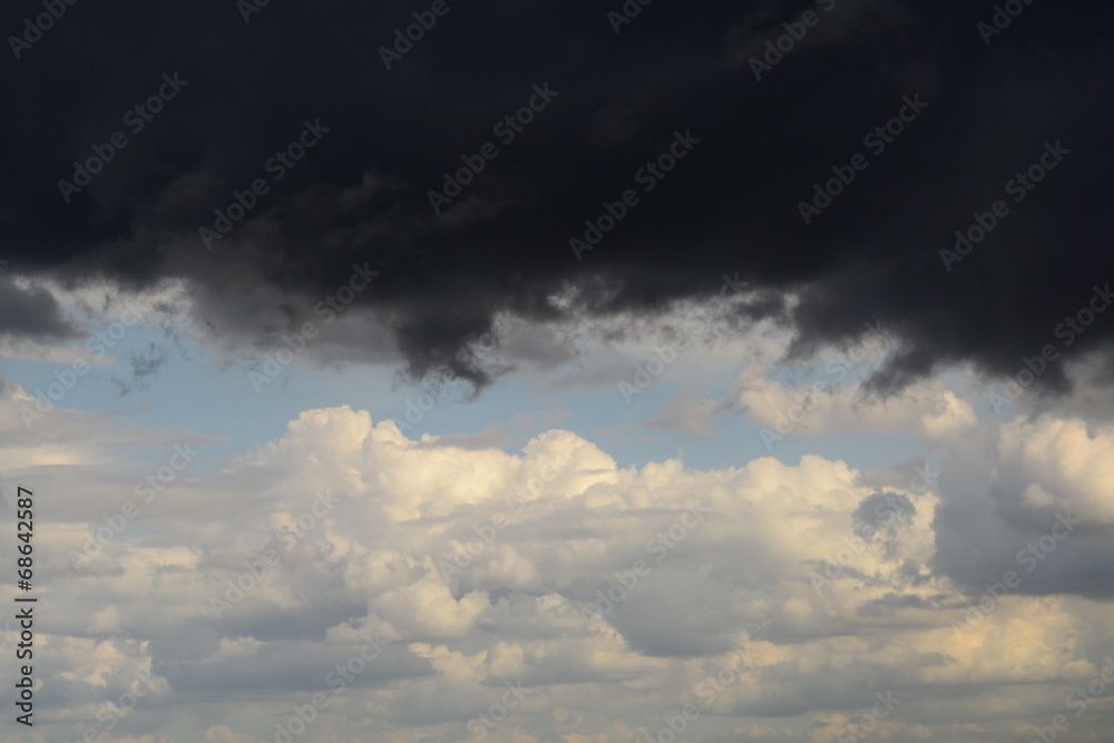 black storm cloud on background of blue sky with white clouds