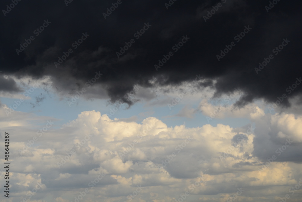black storm cloud on background of blue sky with white clouds black storm cloud on background of blue sky with white clouds