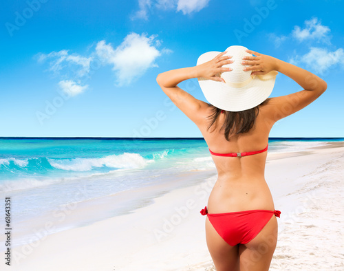 beautiful girl in the back  with hat on tropical beach
