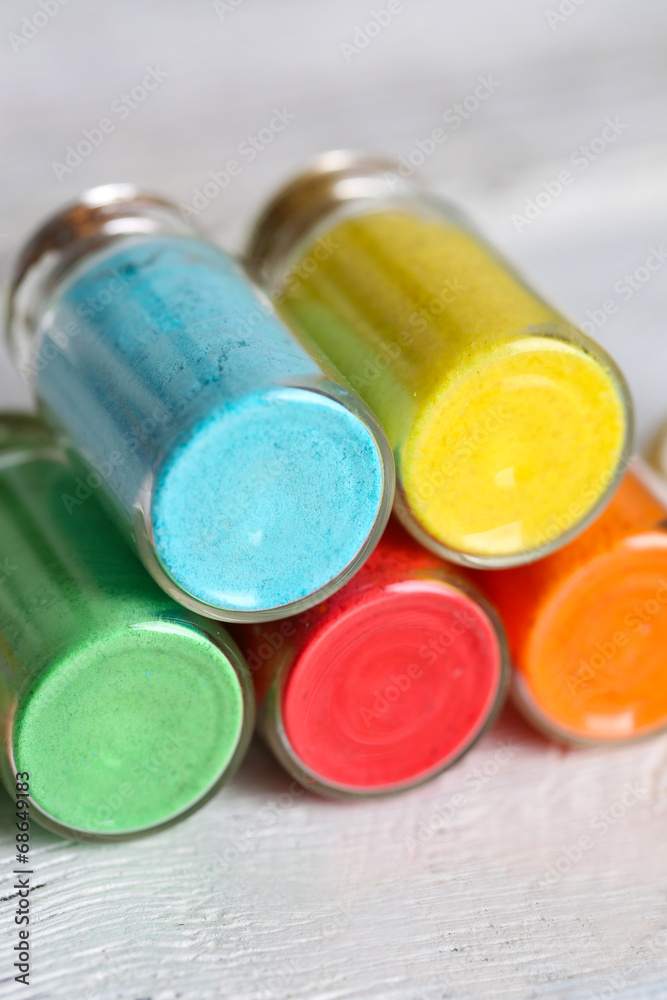 Bottles with colorful dry pigments on wooden background Bottles with colorful dry pigments on wooden background