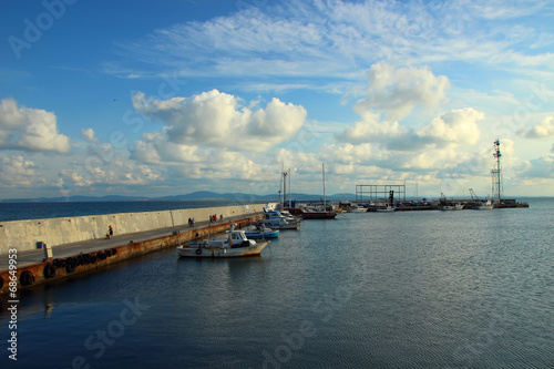 Coastline and boats standing at the pier in the evening. © victoriashuba