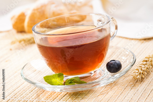 Cup of black tea with mint and fresh berries blueberry