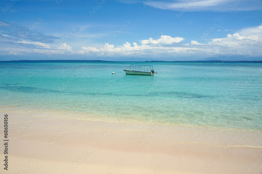 Tropical beach with boat on mooring buoy