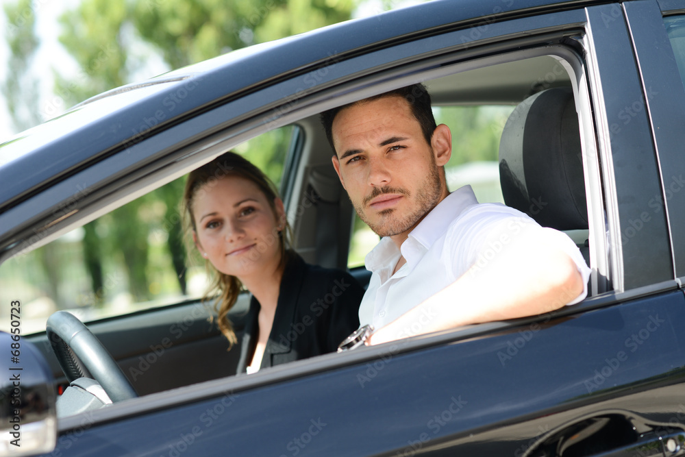 cheerful young business couple in car