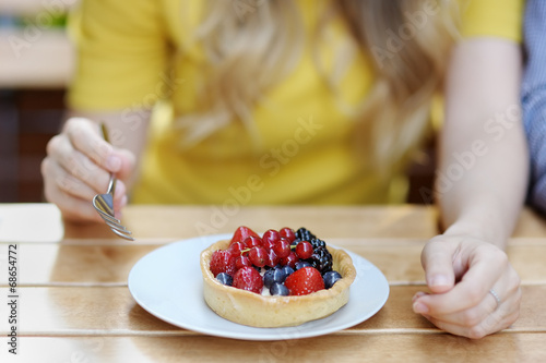 Young woman having fruit tart