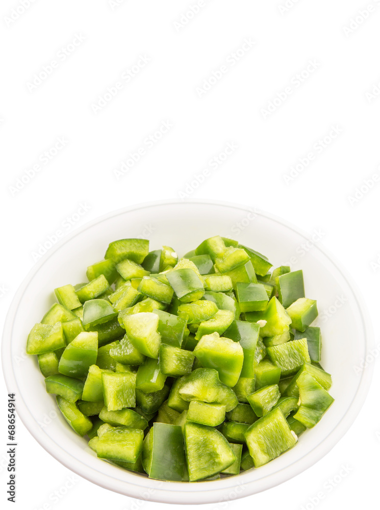 Chopped green capsicums in white bowls over white background Chopped green capsicums in white bowls over white background