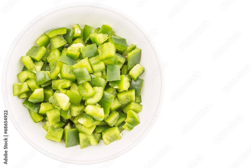 Chopped green capsicums in white bowls over white background Chopped green capsicums in white bowls over white background