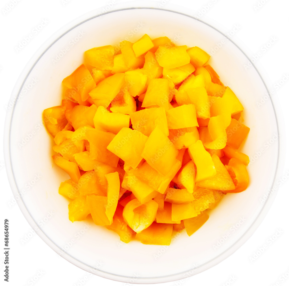 Chopped yellow capsicums in white bowls over white background