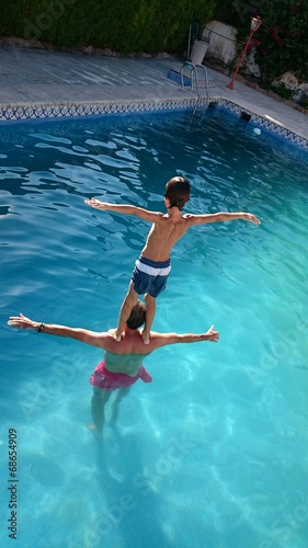 Niño haciendo equilibrio en la piscina