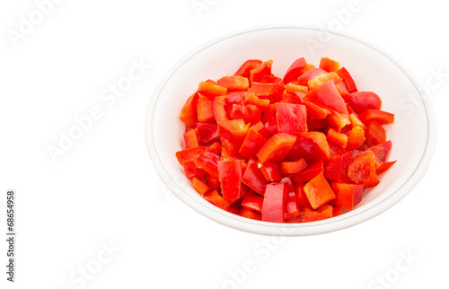 Chopped red capsicums in white bowls over white background