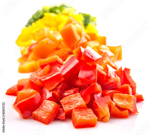 Heaps of chopped colorful capsicums over white background