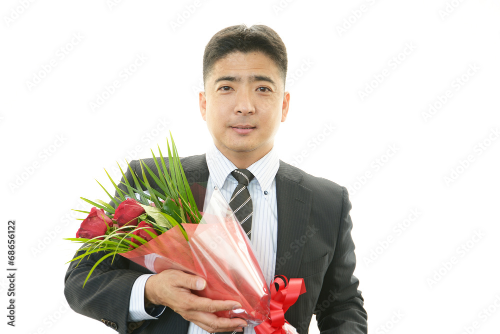花束を持つ笑顔のサラリーマン
