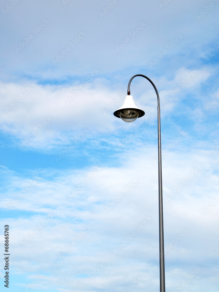 Outdoor public lighting pole with blue sky on background