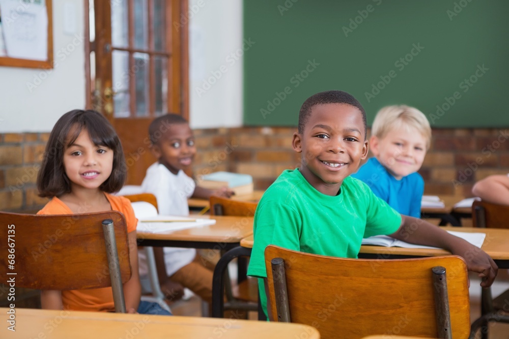 Cute pupils smiling at camera in classroom Cute pupils smiling at camera in classroom