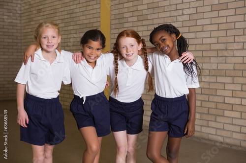 Cute pupils smiling at camera in PE uniform