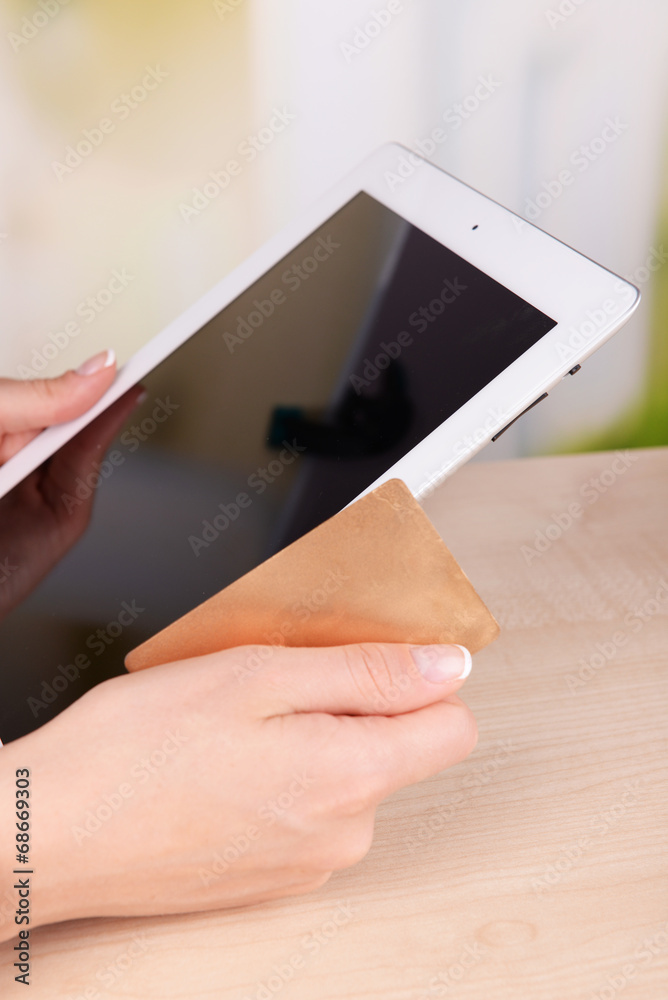 Female hands holding credit card and computer tablet Female hands holding credit card and computer tablet