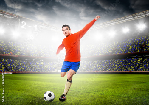 soccer or football player is kicking ball on stadium © Sergey Peterman