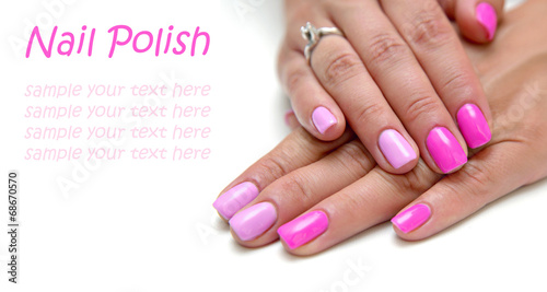 Women's hands with a colored pink nail polish with sample text