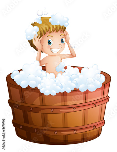 A young boy taking a bath at the big bathtub