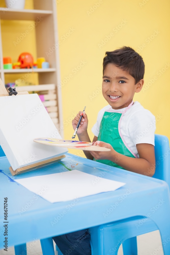 Cute little boy painting at table in classroom Cute little boy painting at table in classroom