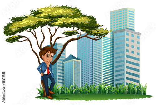 A man under the tree across the tall buildings