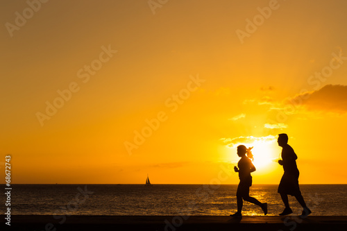 Silhouette of people  jogging at the beach with sunset backgroun © littlestocker