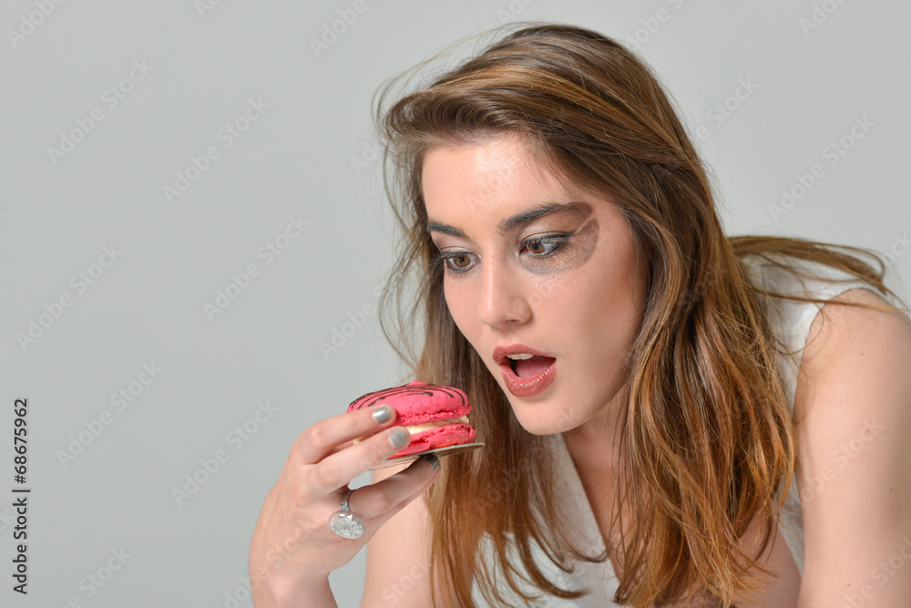 glamour make-up young woman eating pink macaroon