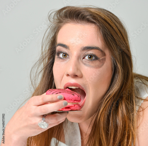 glamour make-up young woman eating pink macaroon