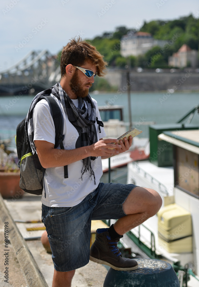 Fototapeta premium young bearded tourist man with backpack and city map