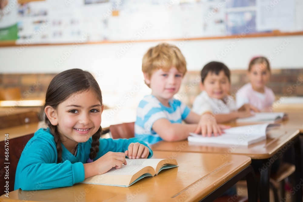 Pupils sitting in classroom reading books Pupils sitting in classroom reading books